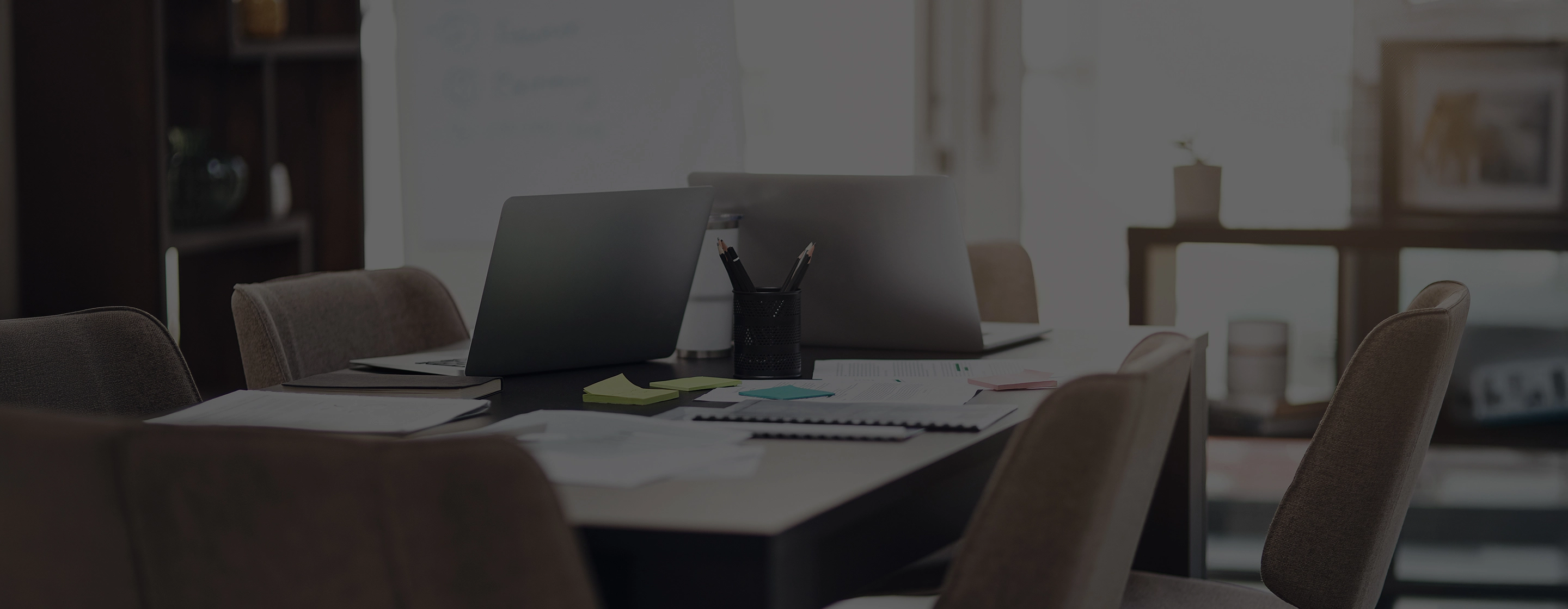 Close-up of architects reviewing blueprints with construction tools, calculator, and safety helmet on the table.